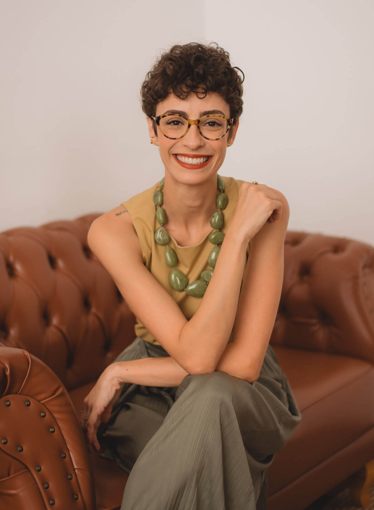 Home 17 Renata psicóloga de braços cruzados olhando para frente e sorrindo